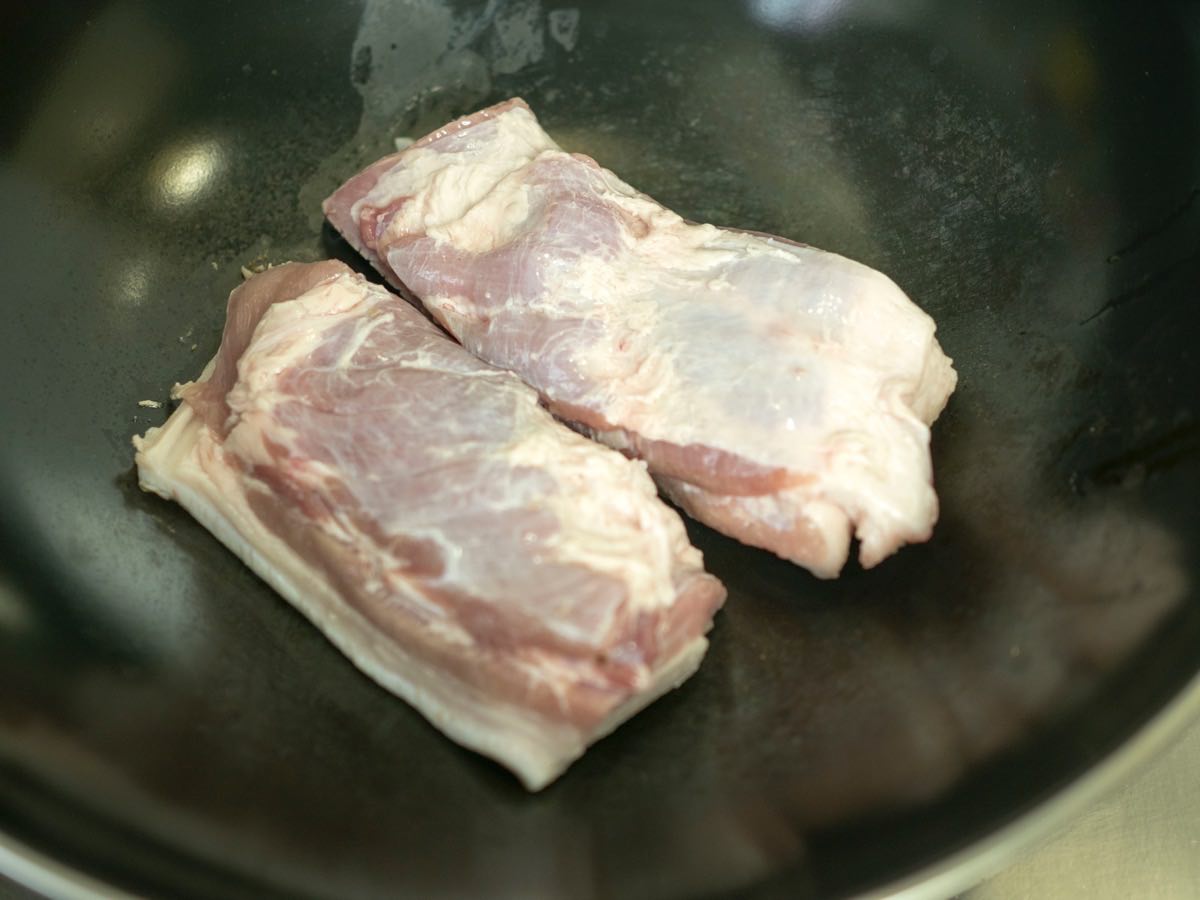 Searing the skin of pork belly